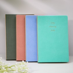 A5 hardcover imitation leather notebook with a mounted spine and gold-stamped logo, dot-matrix paper, and sewn binding